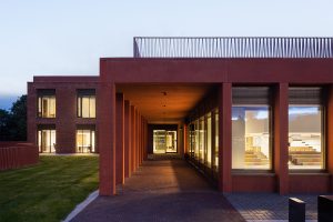 Queens Business School at dusk showing award winning UK architecture and landscaped setting illuminated, designed by Todd Architects, captured in atmospheric evening light by Donal McCann Photography.