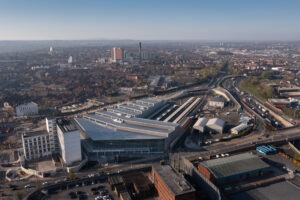Drone shot capturing Belfast Grand Central Station and surrounding cityscape in soft dawn light.