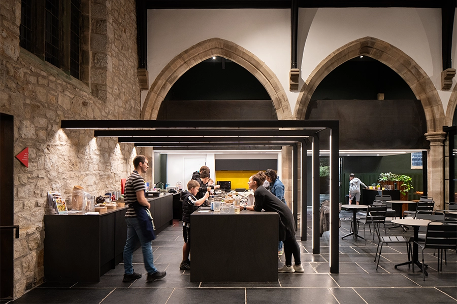 Young children cooking in the Lighthouse Project youth hub, Byker, in a contemporary extension by Bradley McClure Architects.