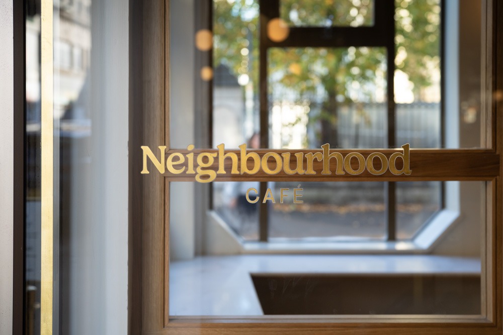 Close-up of elegant lettering on the front door of Neighbourhood Café, Belfast, a top coffee shop in the Cathedral Quarter.