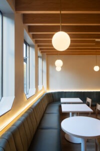 Warm green tones and brass accents at Neighbourhood Café, Belfast, with ambient lighting creating a calm, inviting atmosphere.