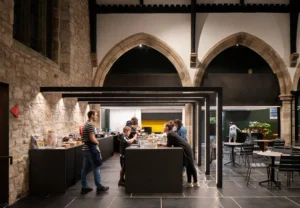 Young children cooking in the Lighthouse Project youth hub, Byker, in a contemporary extension by Bradley McClure Architects.