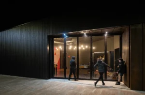 Night shot of children playing outside the Lighthouse Project youth hub in Byker, showing vibrant community use.