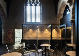 Interior view with stained glass and modern design features, demonstrating Bradley McClure Architects’ sensitive refurbishment.