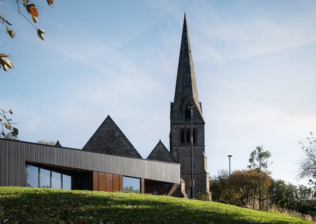Exterior view of the Lighthouse Project showing the contemporary extension blending with historic St Michael’s Church in Byker.