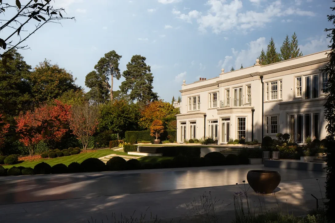 Autumn morning garden view with house nestled among mature trees — UK landscape photography by an architectural photographer.