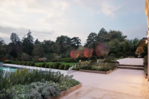 Elegant house and pool in twilight glow surrounded by landscaped garden — UK landscape photography.
