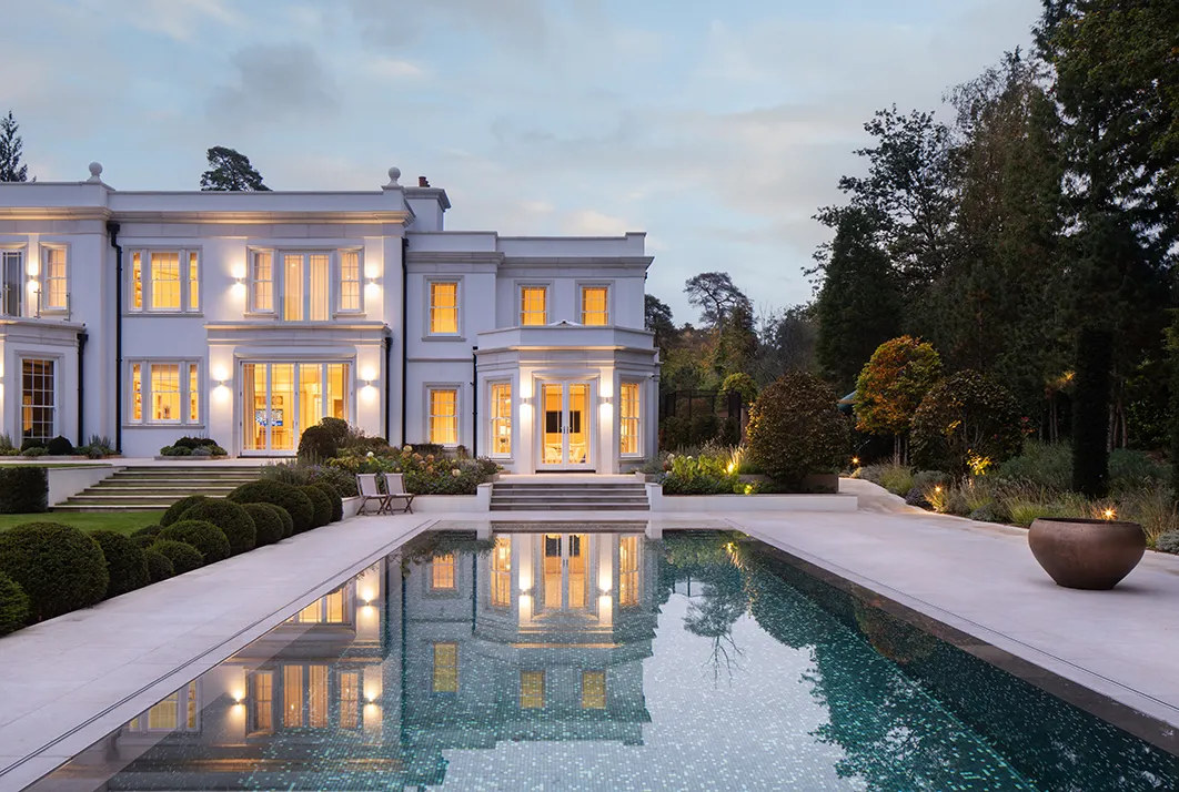Reflections of evening light across pool and terrace — UK architectural photographer.