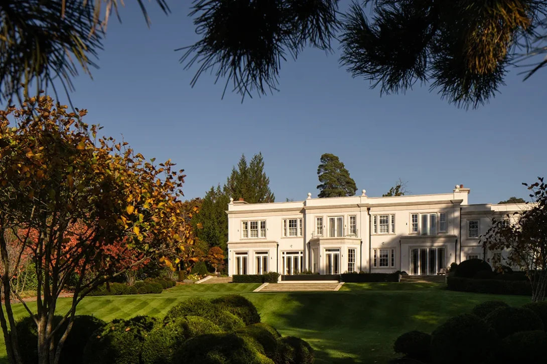 Low sunlight highlighting house and garden textures in early autumn — UK architectural photographer garden composition.
