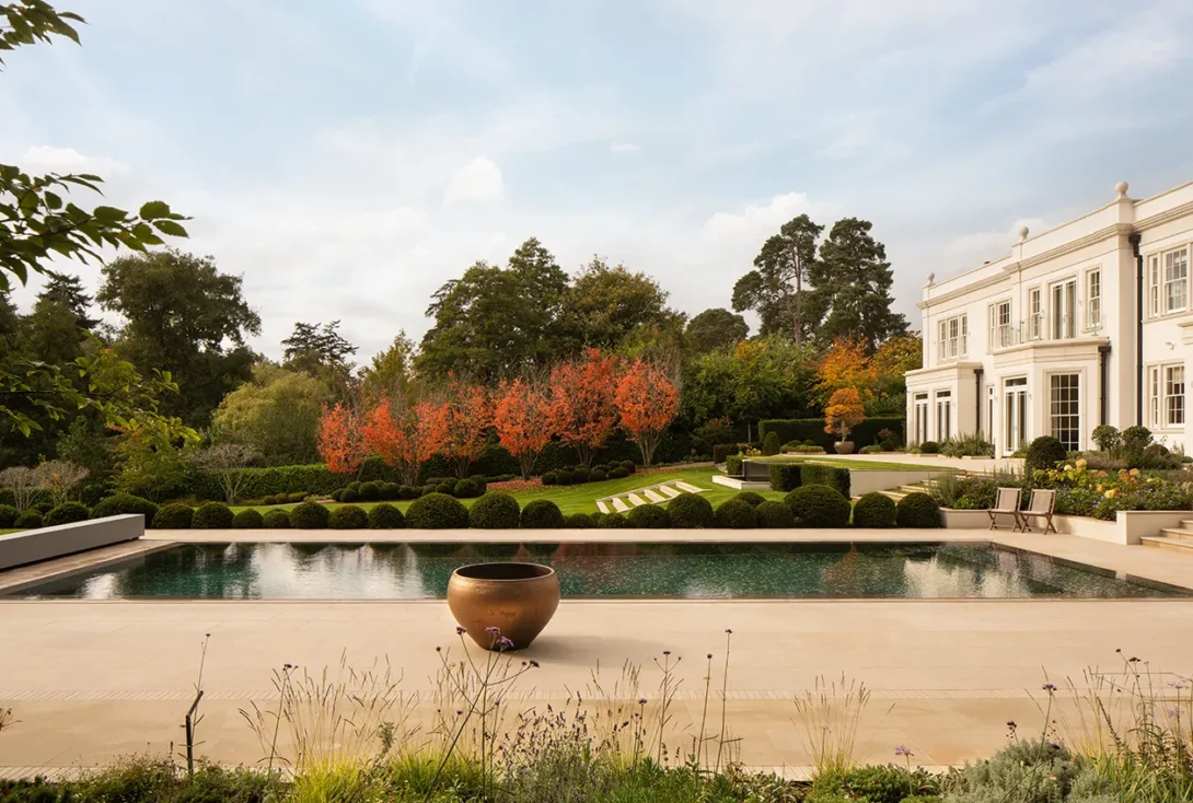 Elegant Surrey house surrounded by autumnal garden captured in soft morning light — UK architectural photographer.
