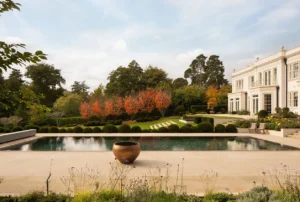 Elegant Surrey house surrounded by autumnal garden captured in soft morning light — UK architectural photographer.