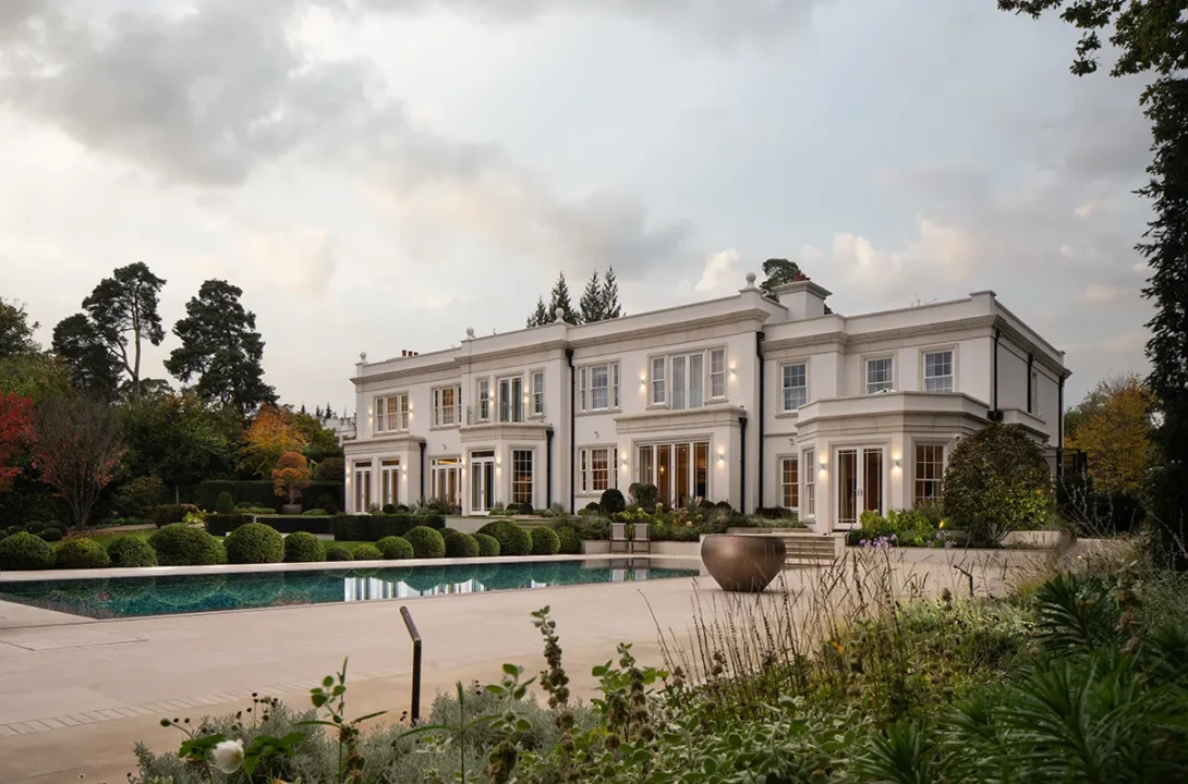 Contemporary Surrey home at dusk with illuminated pool — award winning UK landscape architectural photography.