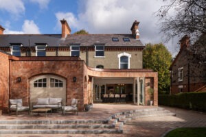 Exterior view of Nest Architects’ Belfast house renovation with bright rear addition and garden connection.