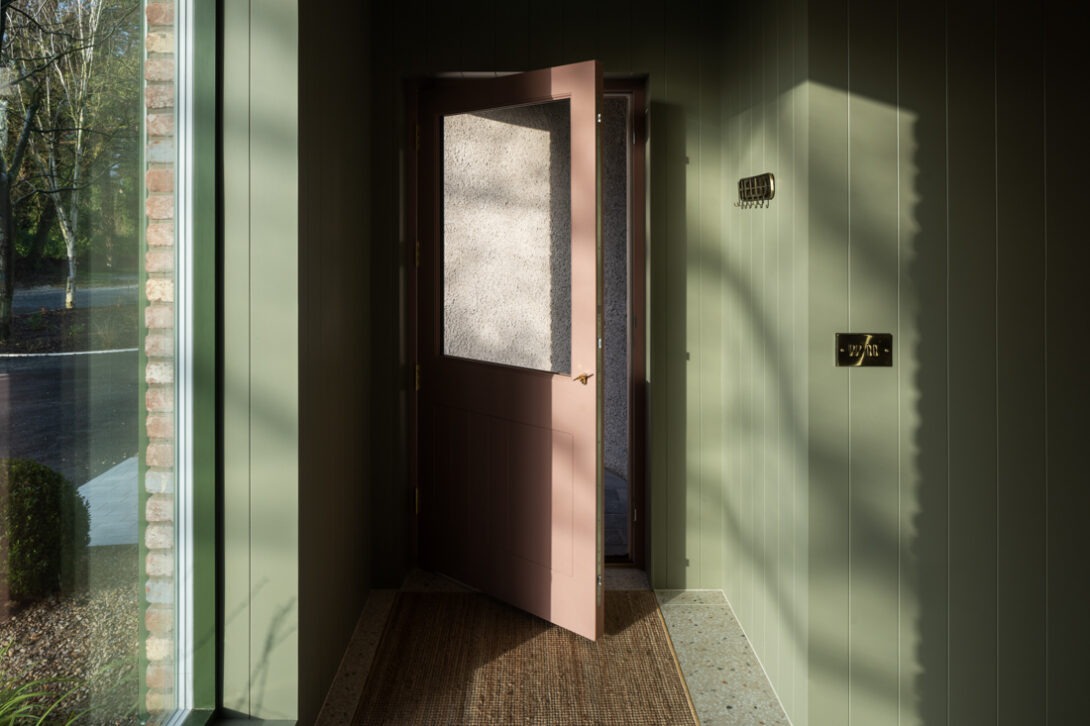 Interior corridor showing natural light streaming across modern finishes and textures in Nest Architects’ The Chalet.