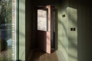 Interior corridor showing natural light streaming across modern finishes and textures in Nest Architects’ The Chalet.