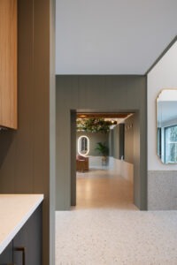 Interior corridor showing natural light streaming across modern finishes and textures in Nest Architects’ The Chalet.